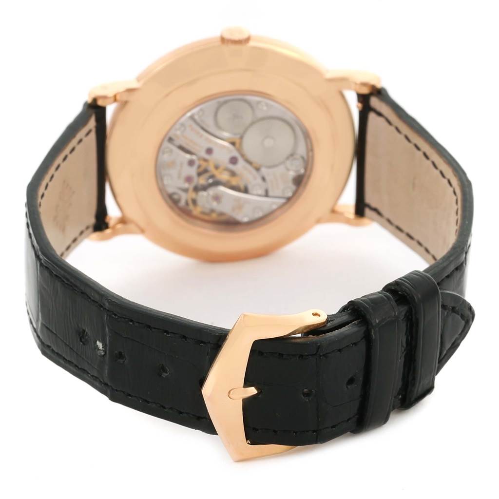 The image shows the back view of the Calatrava watch by Patek Philippe, displaying its movement and leather strap with a buckle.