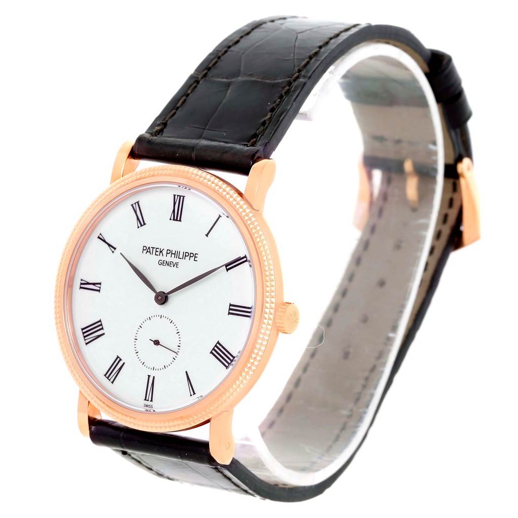 The image shows a Patek Philippe Calatrava 5119 Men
s Rose Gold White Dial 5119 Men
s Rose Gold White Dial watch from a slight side angle, highlighting its dial, crown, and leather strap.