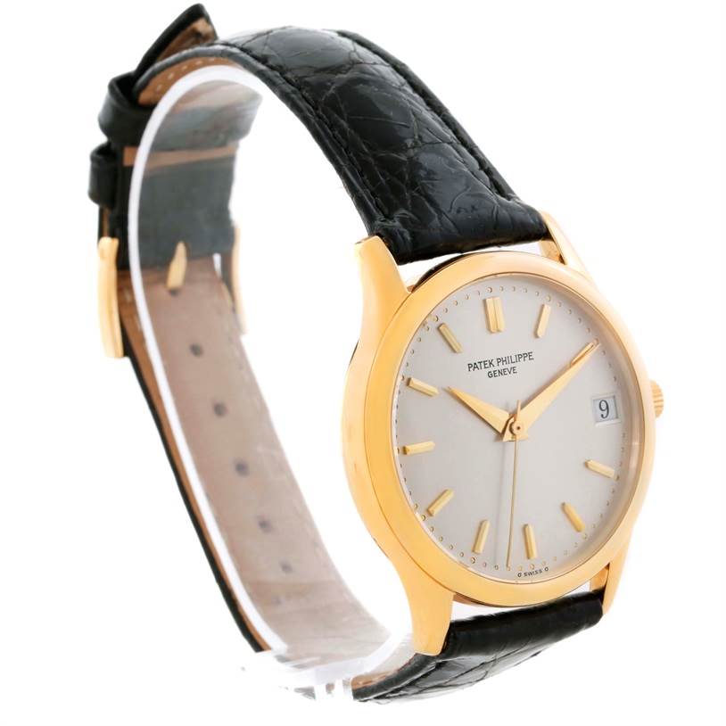 The image displays a Patek Philippe Calatrava 3998 Men's Yellow Gold Silver Dial 3998 Men's Yellow Gold Silver Dial watch at a three-quarter angle, showcasing the face, hands, crown, date window, and leather strap.