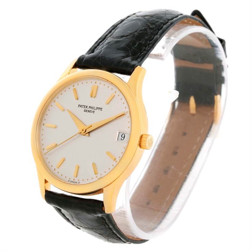 The image shows a Patek Philippe Calatrava 3998 Men's Yellow Gold Silver Dial 3998 Men's Yellow Gold Silver Dial model watch at an angle highlighting its face, crown, and black leather strap.