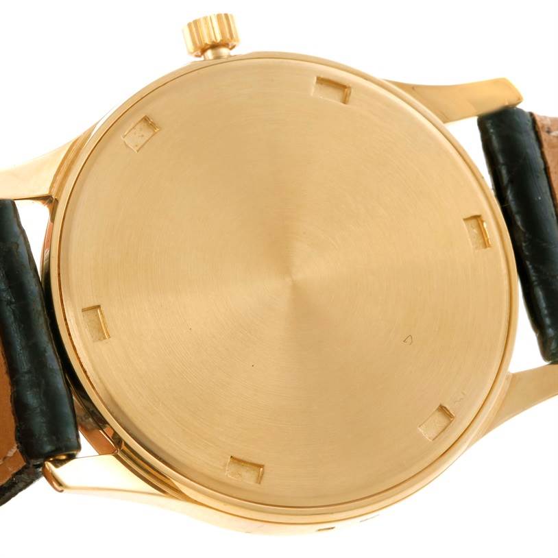 The image shows the back casing and crown of a Patek Philippe Calatrava 3998 Men's Yellow Gold Silver Dial 3998 Men's Yellow Gold Silver Dial watch, highlighting its gold finish and leather strap.