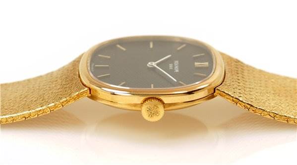 The image shows a side view of the Patek Philippe 3845/2 YEAR 1978 Yellow Gold Black Dial 3845/2 YEAR 1978 Yellow Gold Black Dial Vintage Men 18k Gold Elipse 3845/2 watch, highlighting the crown and case.