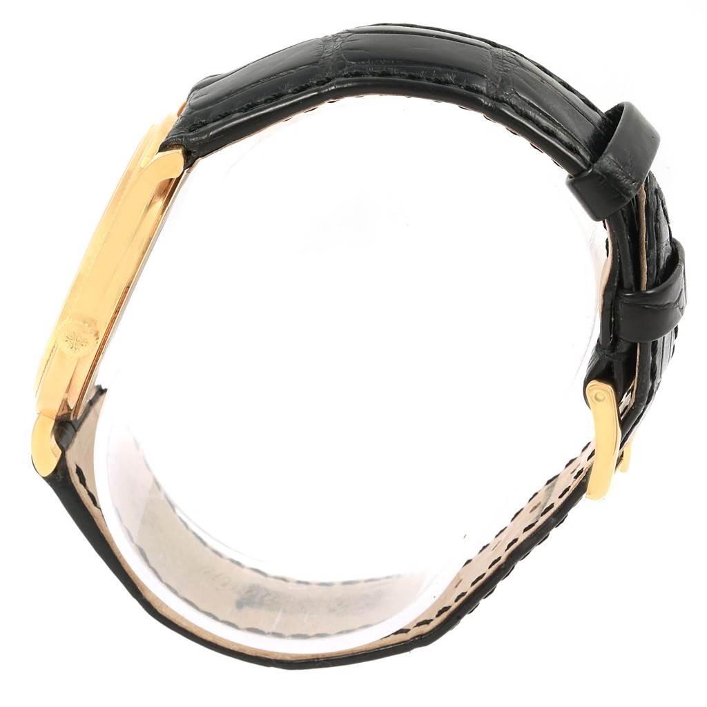 This image shows a side angle of a Patek Philippe Calatrava 5120J Men's Yellow Gold White Dial 5120J Men's Yellow Gold White Dial watch, highlighting the black band and gold case.