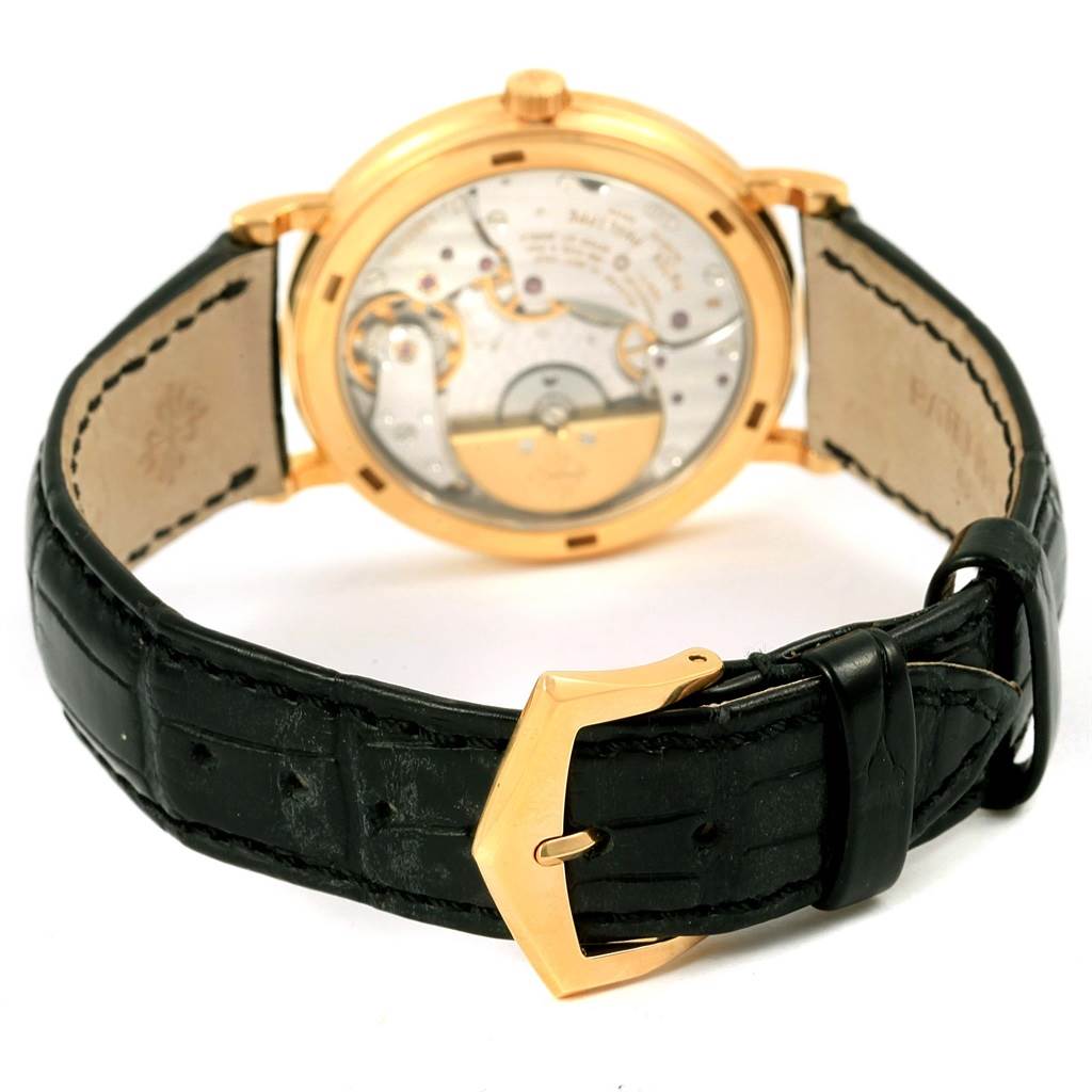 The image shows the back view of the Patek Philippe Calatrava 5120J Men's Yellow Gold White Dial 5120J Men's Yellow Gold White Dial watch, focusing on the intricate movement and black leather strap.