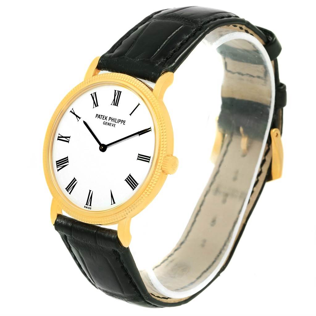 The image shows a Patek Philippe Calatrava 5120J Men's Yellow Gold White Dial 5120J Men's Yellow Gold White Dial watch at a 3/4 angle, revealing the face, bezel, lugs, crown, and leather strap.