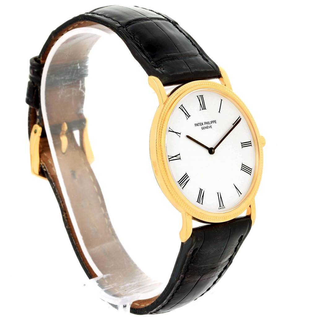 The image shows a side angle of a Patek Philippe Calatrava 3520 Men's Yellow Gold White Dial 3520 Men's Yellow Gold White Dial model watch, featuring a gold case, white dial, and black leather strap.