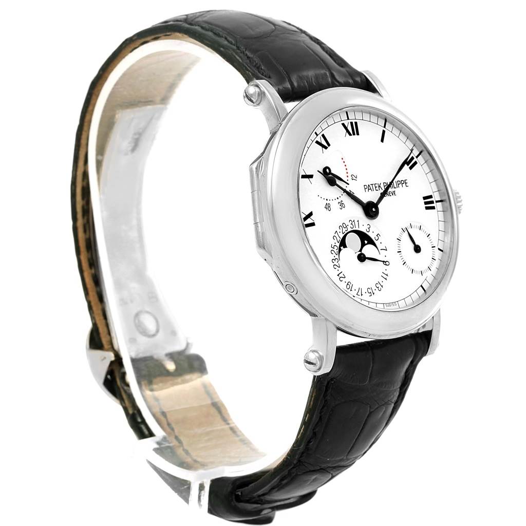 The image shows a Patek Philippe Complications 5054 Men's White Gold White Dial 5054 Men's White Gold White Dial model watch from an angled side view, featuring the face, case, and leather strap.