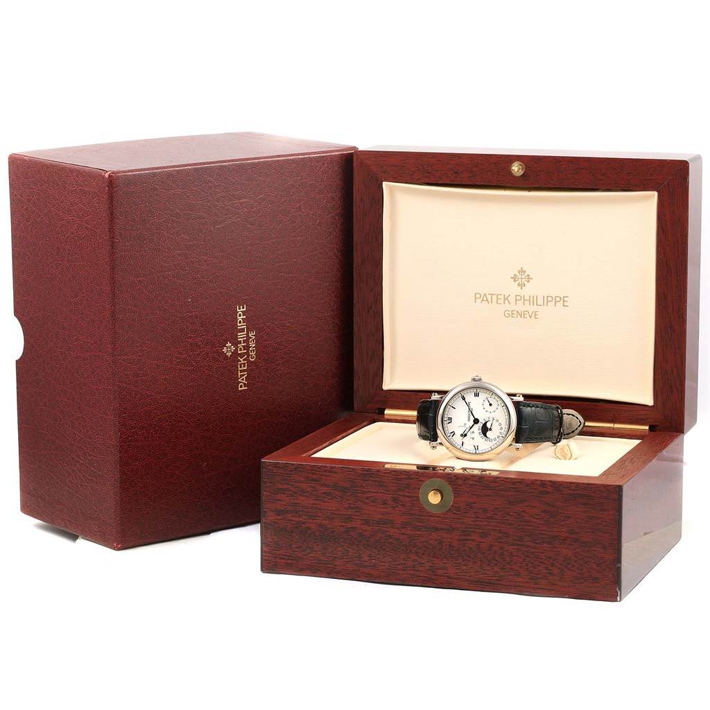 The Patek Philippe Complications 5054 Men's White Gold White Dial 5054 Men's White Gold White Dial model watch is displayed at a front angle in a wooden box, with the outer box also shown.