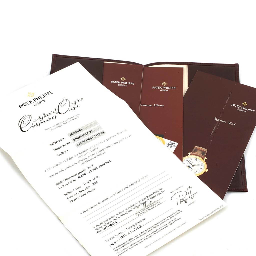 The image shows documentation and accessories for a Patek Philippe Complications 5054 Men's White Gold White Dial 5054 Men's White Gold White Dial watch, including a Certificate of Origin and booklets.