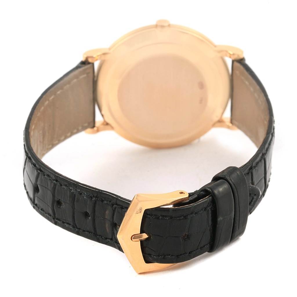 This image shows the back of a Patek Philippe Calatrava 3919 Men's Rose Gold White Dial 3919 Men's Rose Gold White Dial watch and its leather strap with a gold buckle.