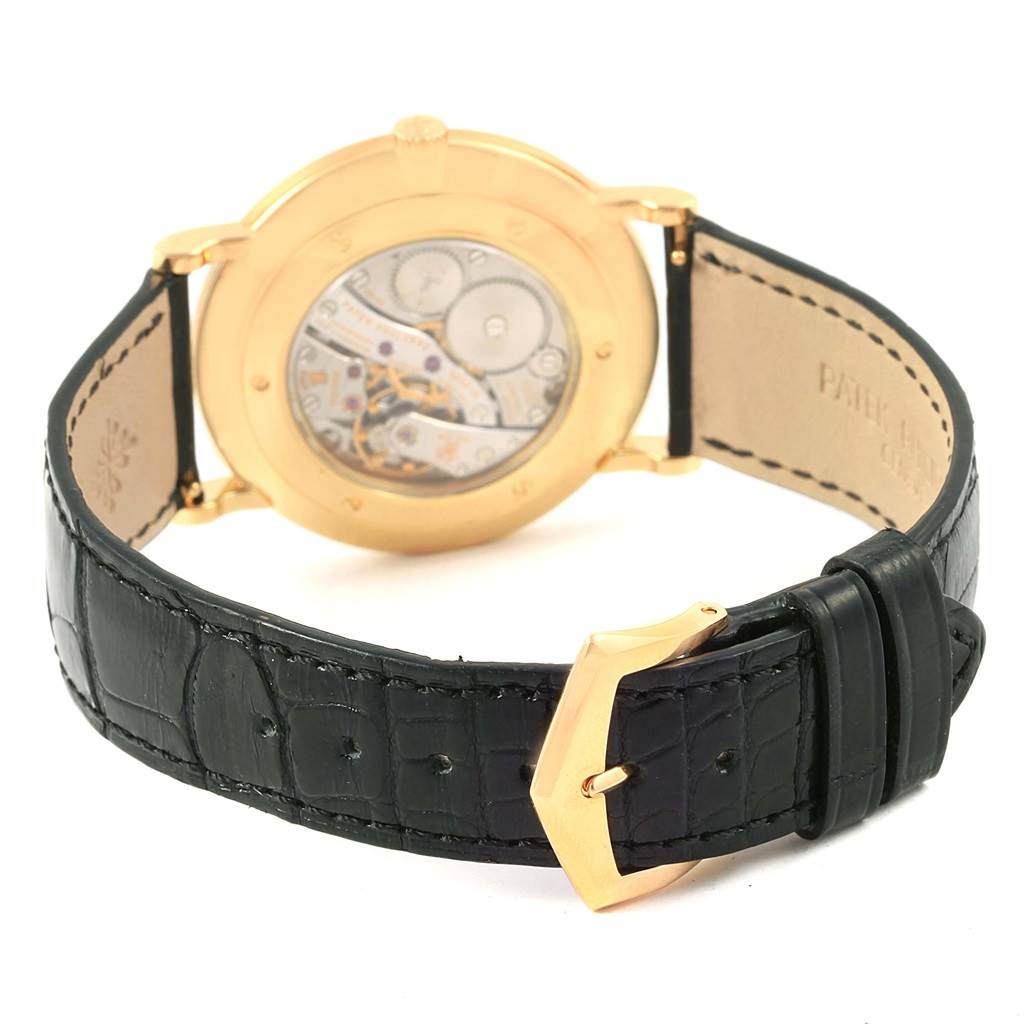 The image shows the back view of a Patek Philippe Calatrava 5119J Men's Yellow Gold White Dial 5119J Men's Yellow Gold White Dial watch, highlighting its mechanical movement and black leather strap.