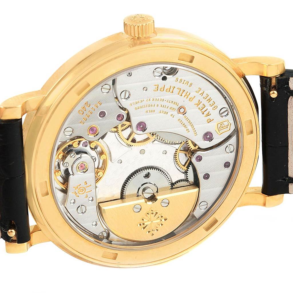 The image shows the back of the Patek Philippe Calatrava 5120J Men's Yellow Gold White Dial 5120J Men's Yellow Gold White Dial watch, highlighting its internal mechanical movement.