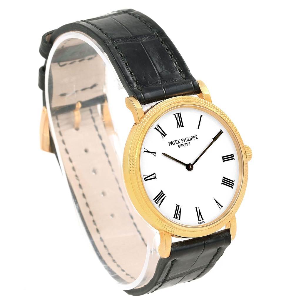 The image shows a front-side view of the Patek Philippe Calatrava 5120J Men's Yellow Gold White Dial 5120J Men's Yellow Gold White Dial watch, featuring its gold case, white dial, and black leather strap.