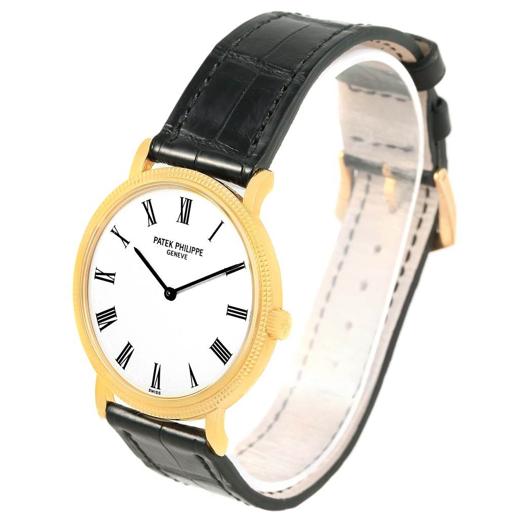 The image shows a Patek Philippe Calatrava 5120J Men's Yellow Gold White Dial 5120J Men's Yellow Gold White Dial watch from a top-front angle, displaying its dial, case, and leather strap.