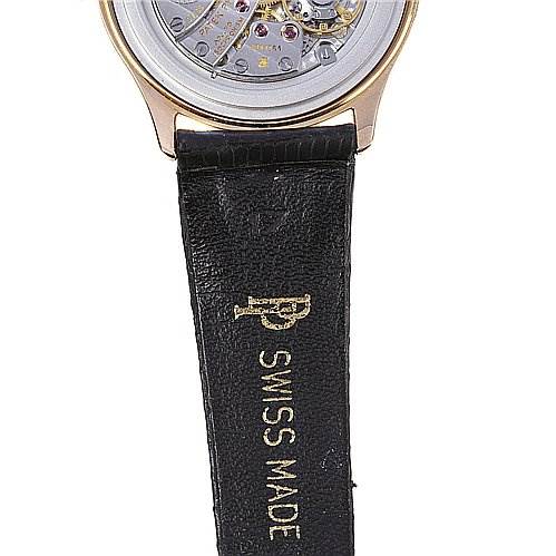 This image shows the back of a Calatrava model by Patek Philippe, highlighting the movement and part of the black leather strap.