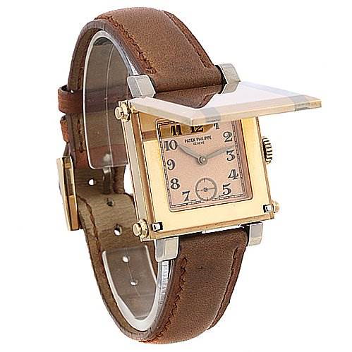 The image shows a side angle of a Patek Philippe Gondolo watch with a raised crystal cover, revealing its square face and leather strap.