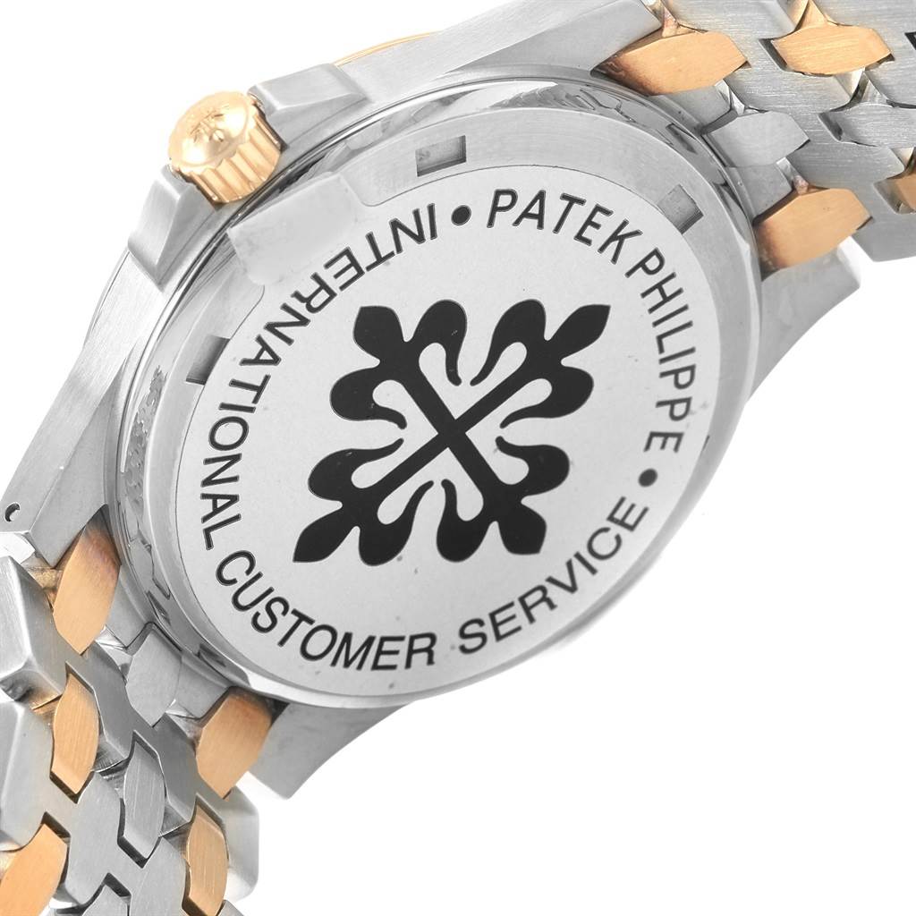 The image shows the back and part of the bracelet of a Patek Philippe Neptune 5080/IJA Men's Steel and Gold (two tone) Black Dial 5080/IJA Men's Steel and Gold (two tone) Black Dial model, displaying the brand's emblem and service information.