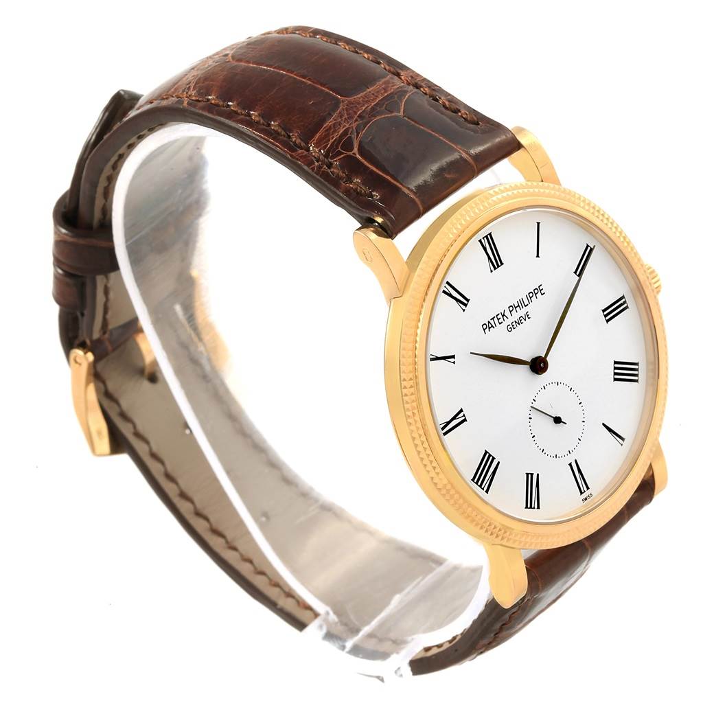 The image shows a side angle view of the Patek Philippe Calatrava 5119J Men's Yellow Gold White Dial 5119J Men's Yellow Gold White Dial watch, highlighting its brown leather strap and gold case with a white dial.