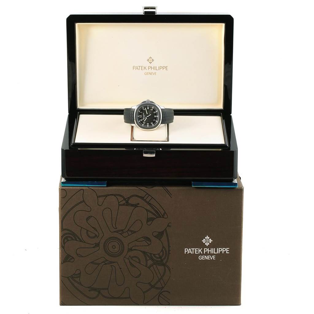 The Patek Philippe Aquanaut 5167A Men's Stainless Steel Black Dial 5167A Men's Stainless Steel Black Dial watch is displayed front-on within an open presentation box, placed on top of the outer packaging.
