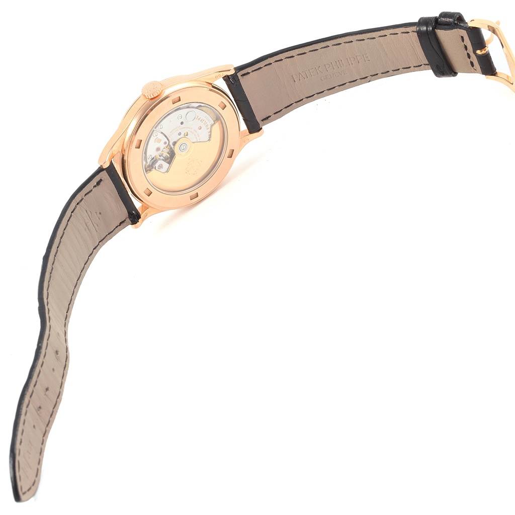 The image shows the reverse side of a Patek Philippe Calatrava 5296R-001 Men
s Rose Gold Silver Dial 5296R-001 Men
s Rose Gold Silver Dial watch, highlighting the movement and leather strap.