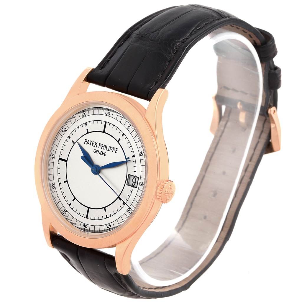The image shows a side view of a Calatrava model by Patek Philippe, displaying the watch face, crown, and leather strap.