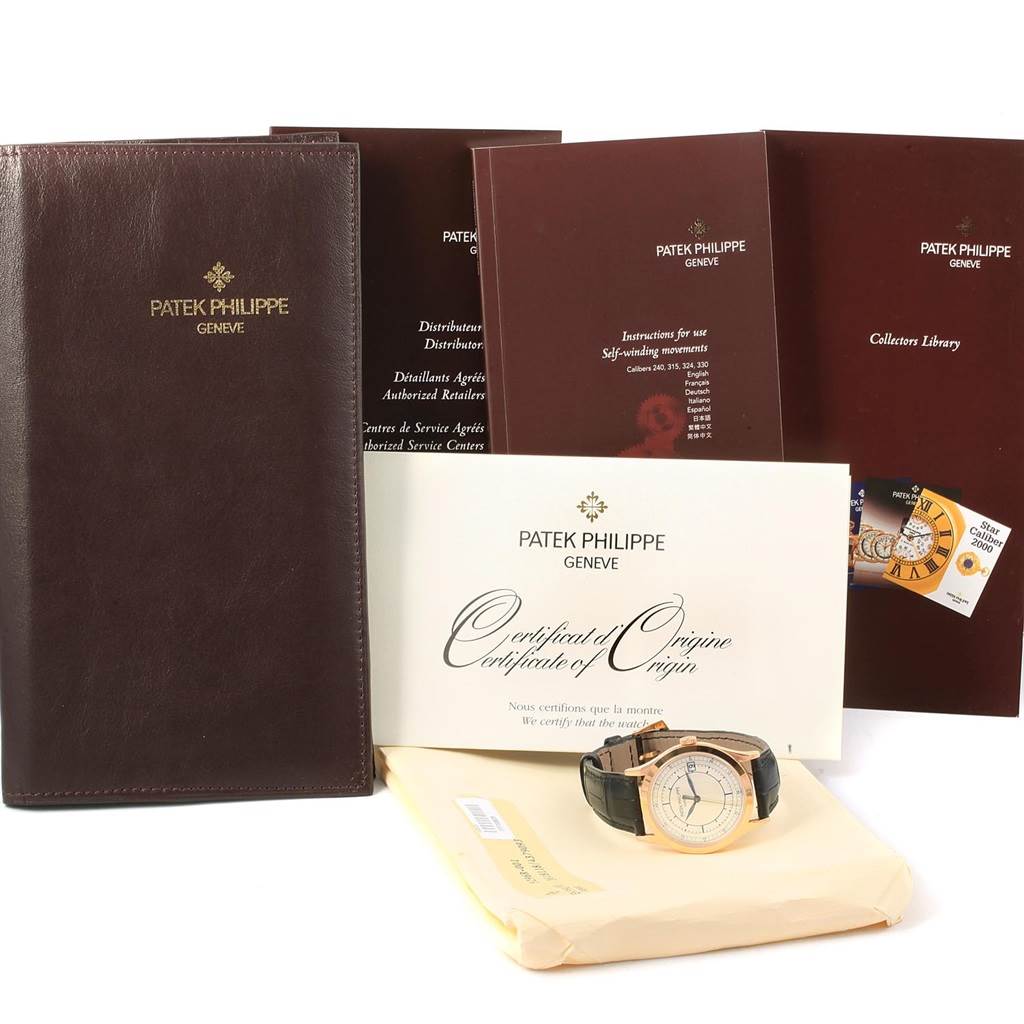 The image shows a Patek Philippe Calatrava 5296R-001 Men
s Rose Gold Silver Dial 5296R-001 Men
s Rose Gold Silver Dial watch with accompanying documents and accessories displayed from a top view angle.