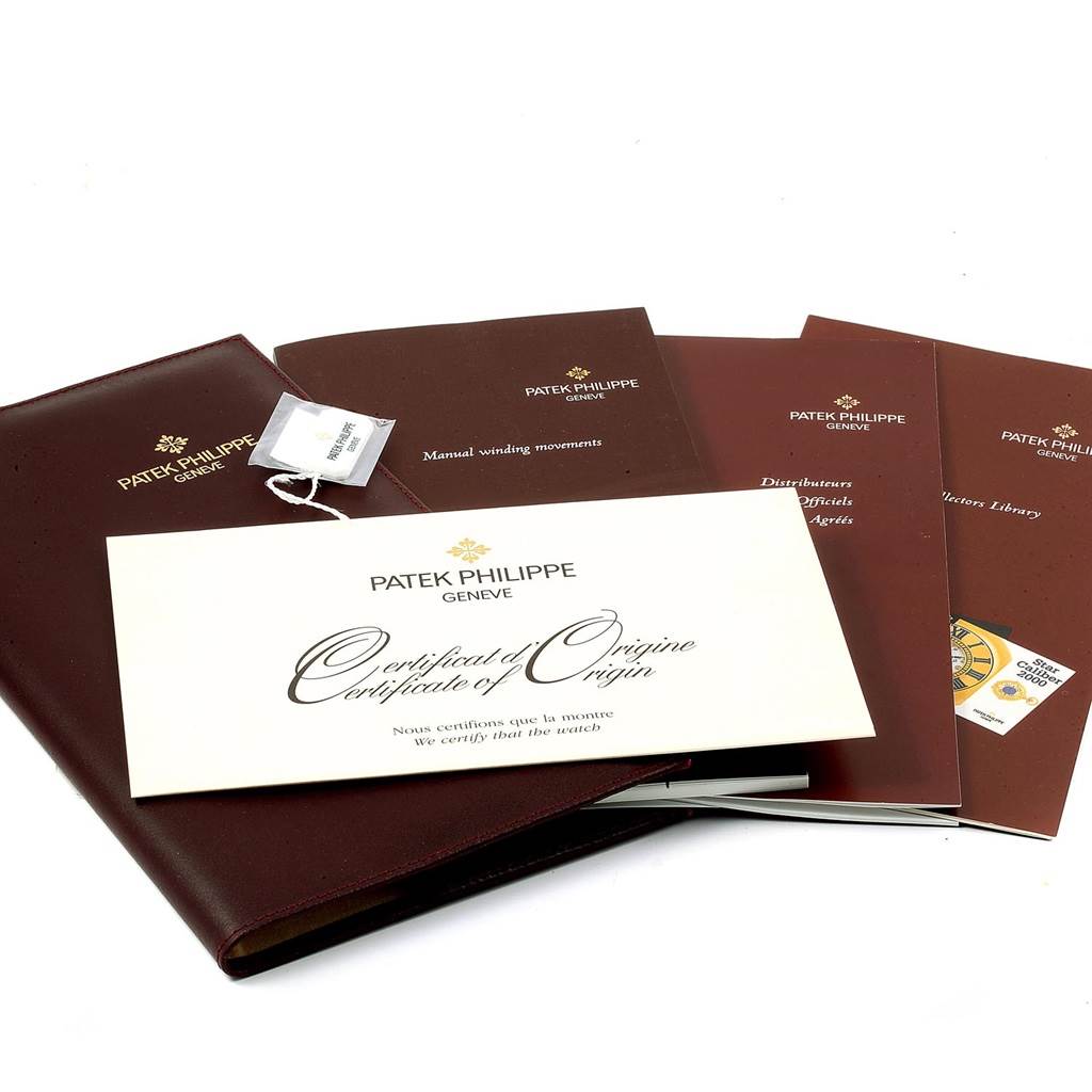 The image shows documentation and booklets, including a Certificate of Origin for the Patek Philippe Gondolo 5010R Men's Rose Gold Silver Dial 5010R Men's Rose Gold Silver Dial watch.