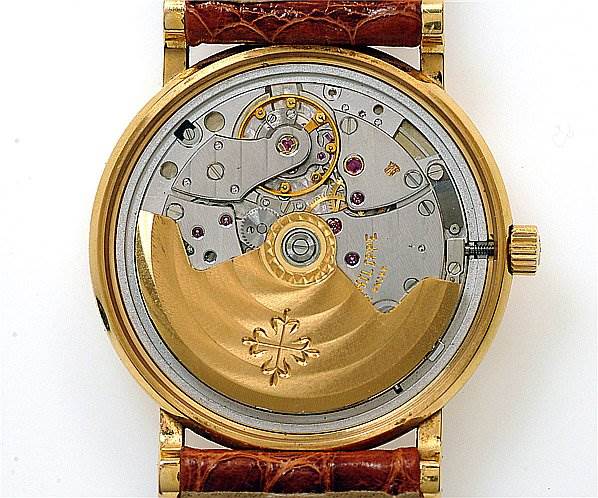 This image shows the back view of a Patek Philippe Calatrava 3802/200 Men's Yellow Gold White Dial 3802/200 Men's Yellow Gold White Dial watch, highlighting its intricate mechanical movement.