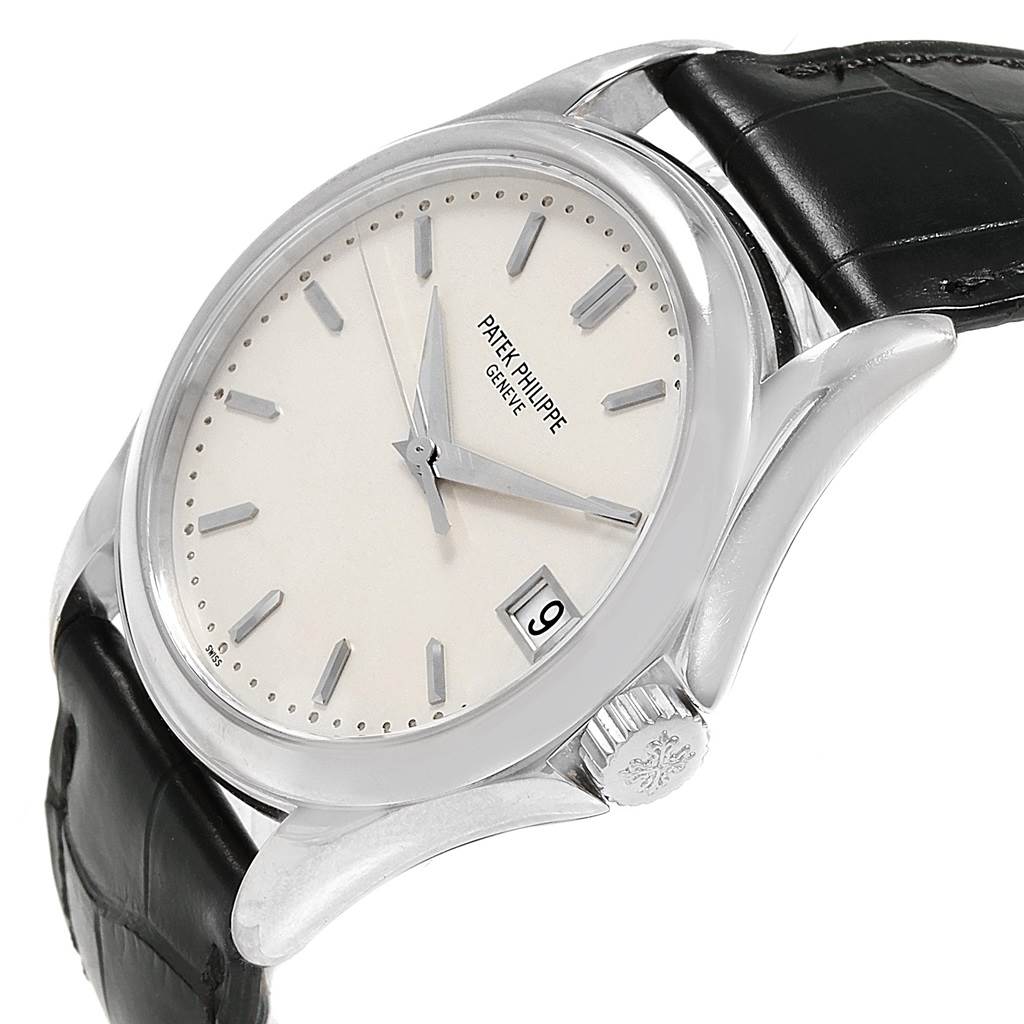The image shows a Patek Philippe Calatrava 5127G Men's White Gold White Dial 5127G Men's White Gold White Dial watch angled from the front-right, displaying its face, crown, and part of the strap.