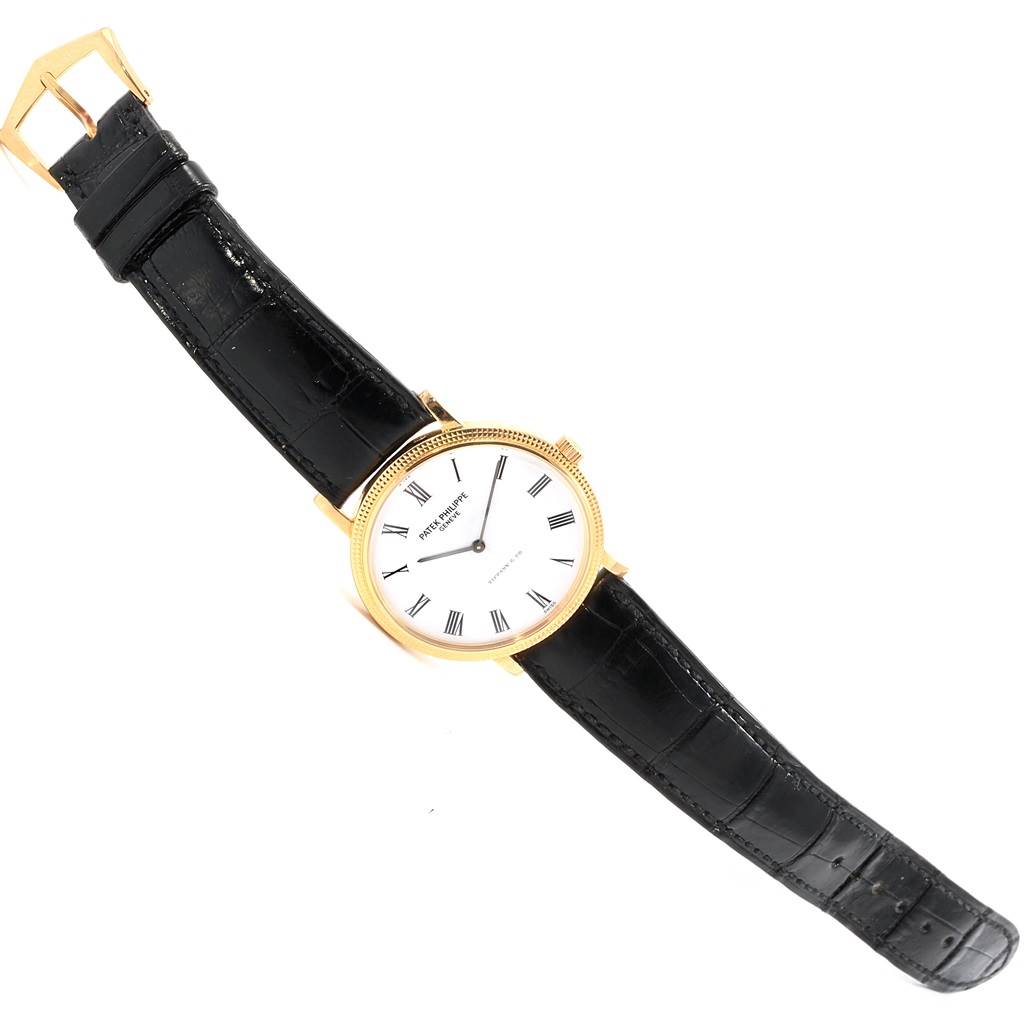 The image shows a Patek Philippe Calatrava 5120J Men's Yellow Gold White Dial 5120J Men's Yellow Gold White Dial model watch, with a frontal view displaying the full face and black leather strap.