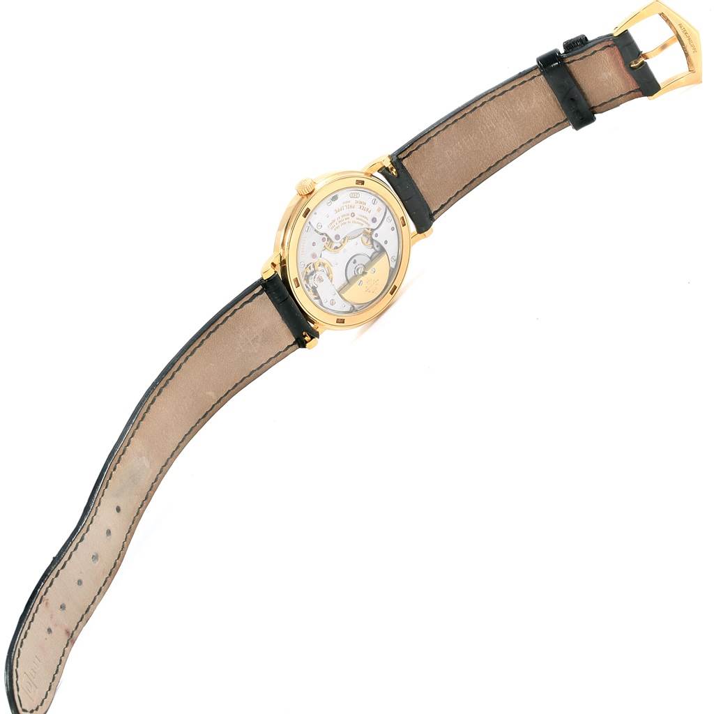 The image shows the back view of a Patek Philippe Calatrava 5120J Men's Yellow Gold White Dial 5120J Men's Yellow Gold White Dial watch, highlighting its movement and inner mechanics.