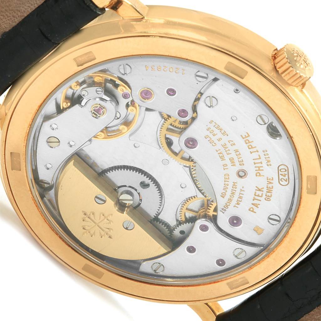The image shows the back view of a Patek Philippe Calatrava 5120J Men's Yellow Gold White Dial 5120J Men's Yellow Gold White Dial watch, revealing its intricate mechanical movement.