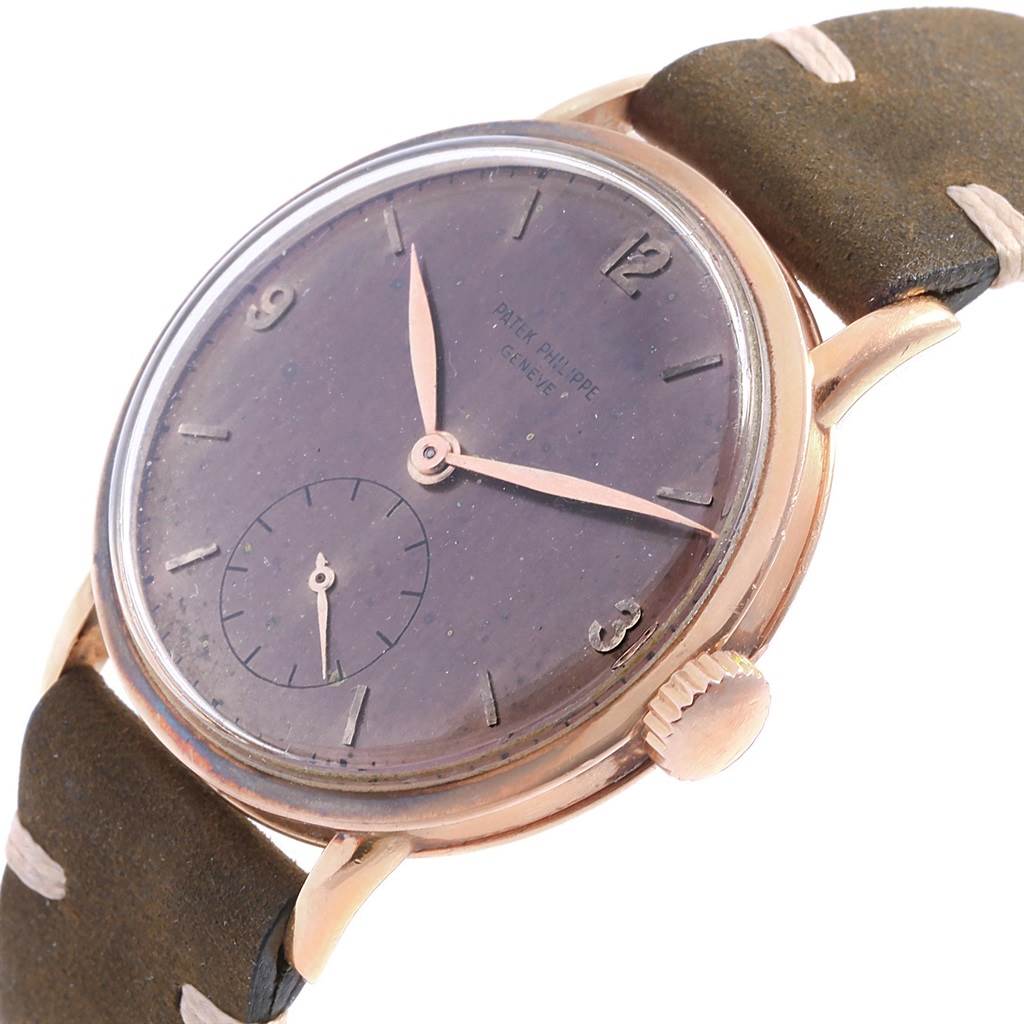 The image shows a vintage Patek Philippe watch at a slight angle, highlighting the dial, crown, and part of the strap.