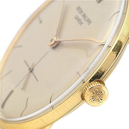 The image shows a close-up, side angle of a Vintage Patek Philippe watch highlighting its gold case and crown.