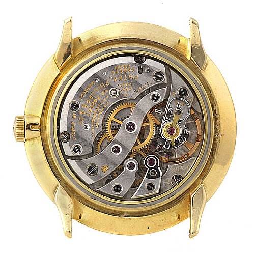 The image shows the back view of a Vintage Patek Philippe watch, revealing its intricate mechanical movement.