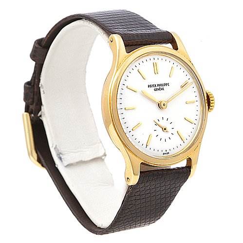 This image shows a Vintage Patek Philippe watch at a three-quarter angle, displaying its gold case, white dial, and brown leather strap.