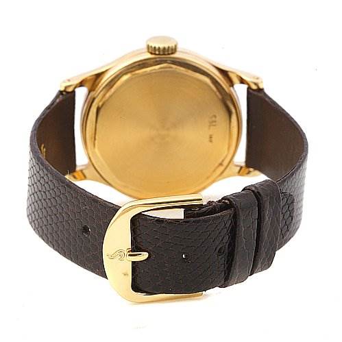 The image shows the back of a Vintage Patek Philippe watch, highlighting the gold case and the textured black leather strap with a gold buckle.