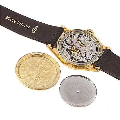 The image shows the back of a Vintage Patek Philippe watch, revealing its movement and removed case back.