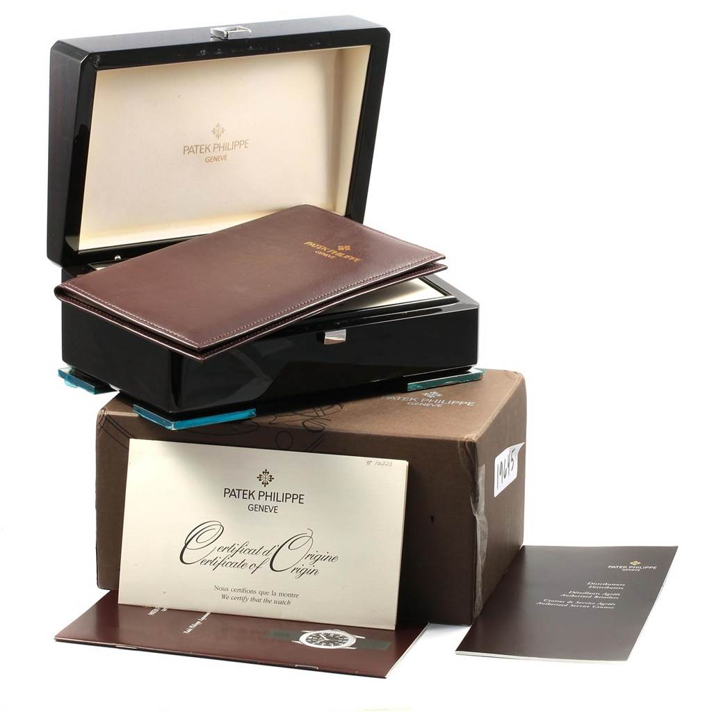 The image shows the packaging, certificate, and booklet for a Patek Philippe Aquanaut PATEK PHILIPPE Men's Stainless Steel Black Dial PATEK PHILIPPE Men's Stainless Steel Black Dial watch, viewed from an angle above.