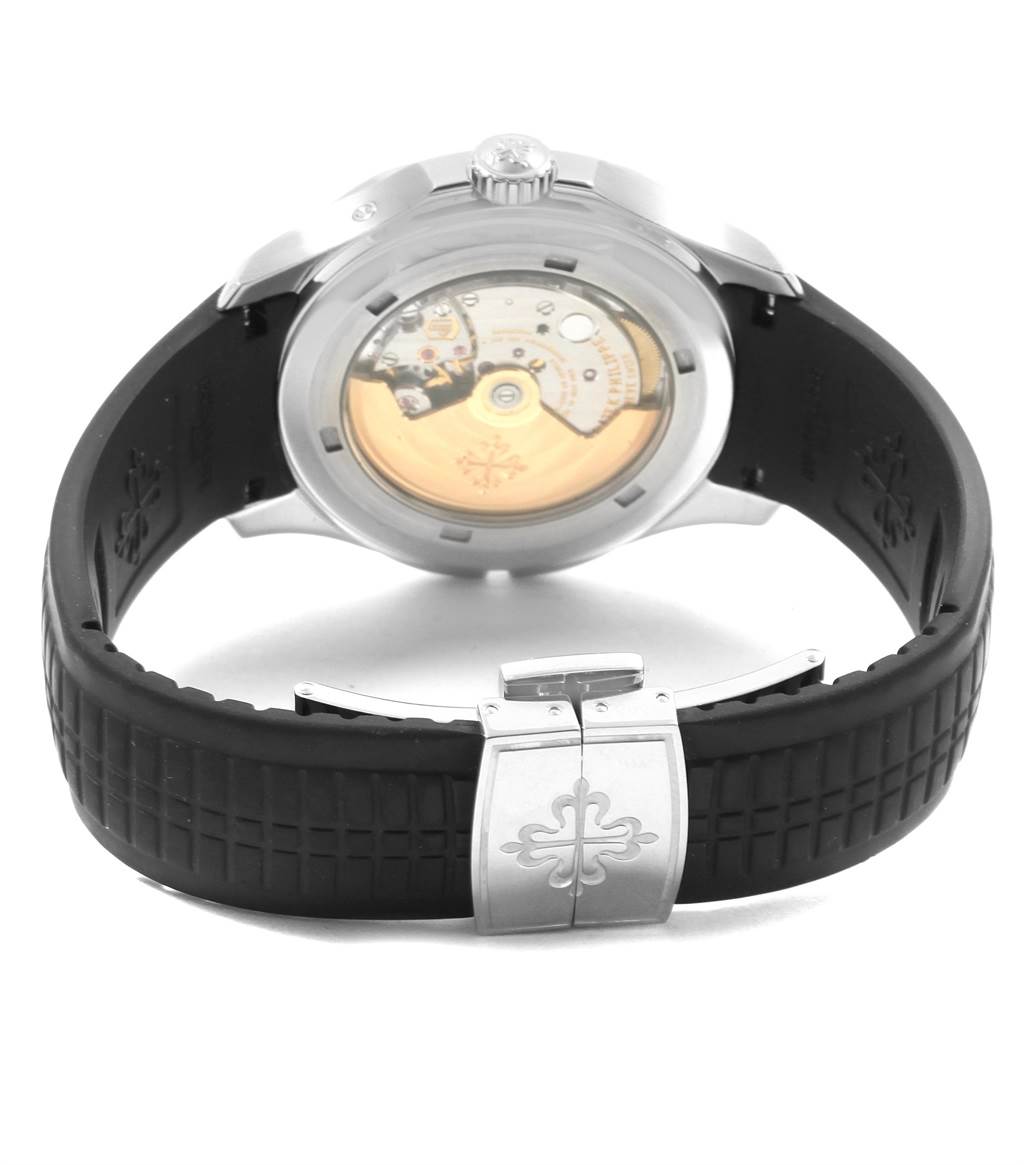 The image shows the back of a Patek Philippe Aquanaut 5164A Men's Stainless Steel Black Dial 5164A Men's Stainless Steel Black Dial watch, highlighting the movement mechanism and black strap with clasp.