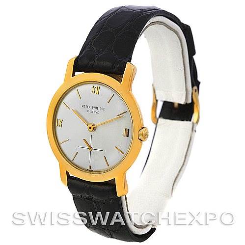 The image shows a side angle of a Vintage Patek Philippe watch featuring a gold case, white dial, and black leather strap.