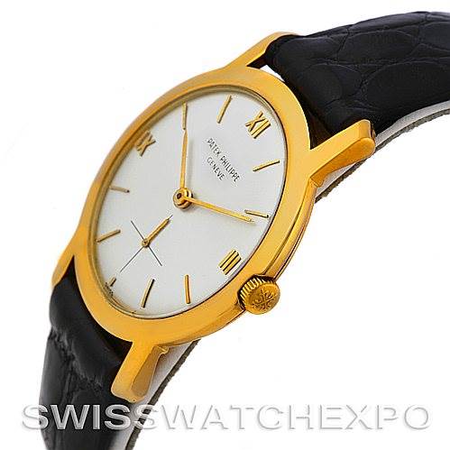 The image shows a side angle of a Vintage Patek Philippe watch, highlighting its gold case, white dial, and black leather strap.