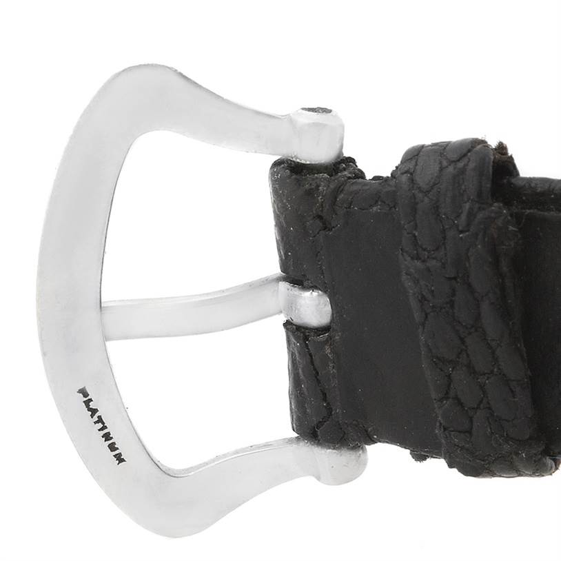 This image shows a close-up of the leather strap and platinum buckle of a Vintage Patek Philippe watch.