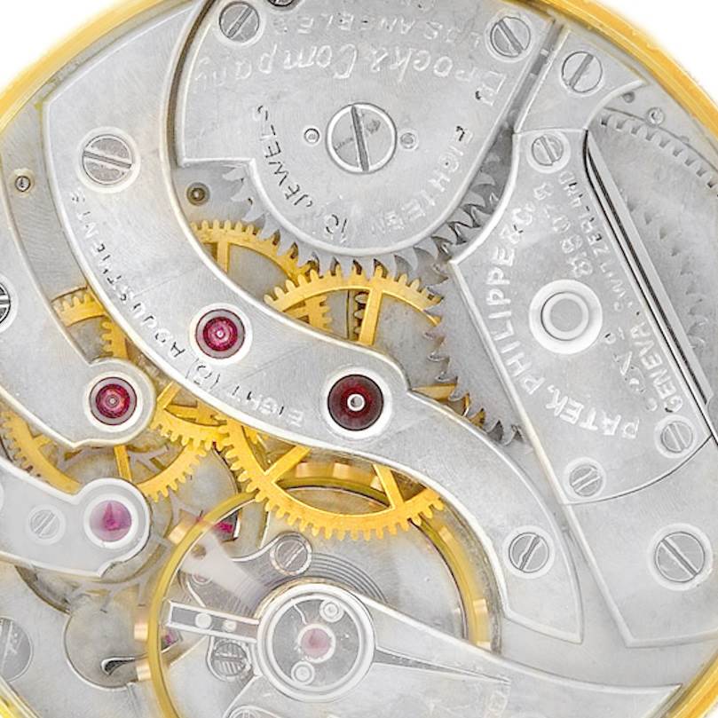 The image shows an angled view of the internal mechanics and gears of a vintage Patek Philippe watch.