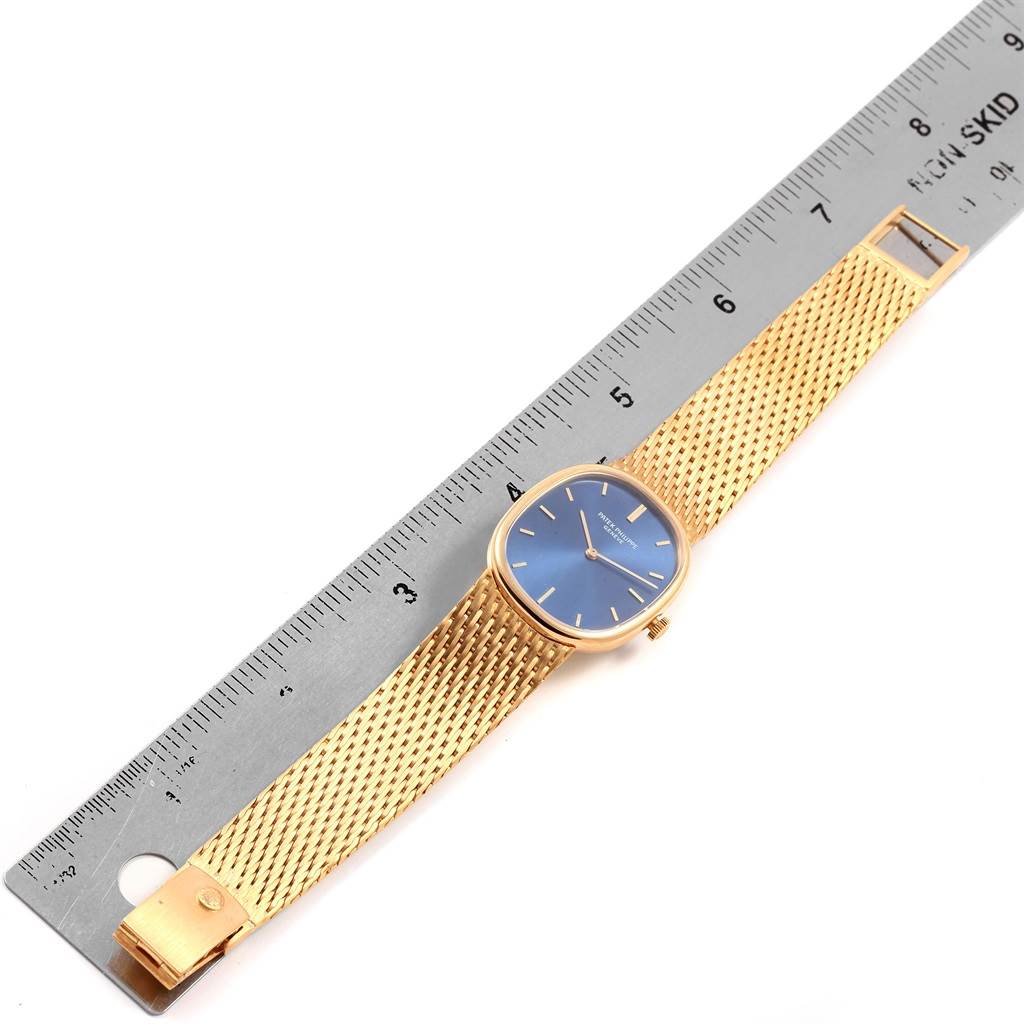 The image shows a Patek Philippe Golden Ellipse 3548 Men's Yellow Gold Blue Dial 3548 Men's Yellow Gold Blue Dial watch with a blue face and gold bracelet, laid beside a ruler for scale.