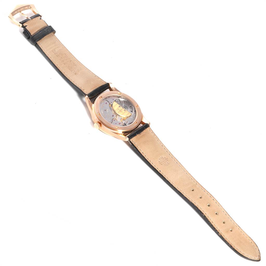 This image shows the backside of a Patek Philippe Calatrava 5026R Men's Rose Gold Black Dial 5026R Men's Rose Gold Black Dial watch, highlighting its open case back and leather strap.