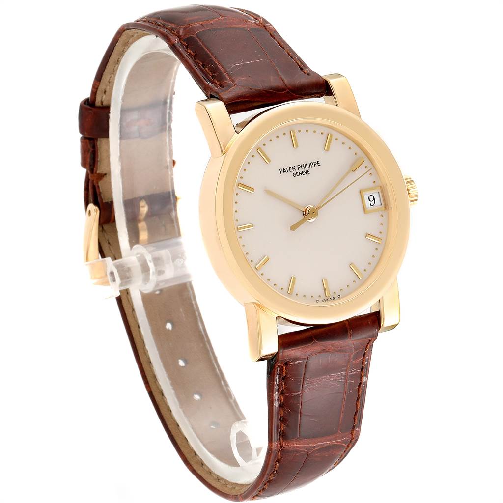This image shows a Patek Philippe Calatrava 5012 Men's Yellow Gold Beige Dial 5012 Men's Yellow Gold Beige Dial watch from an angled side view, highlighting its dial, gold case, and brown leather strap.