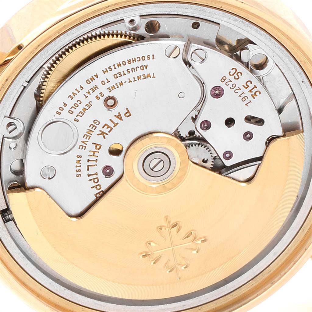 This image shows the back of a Patek Philippe Calatrava 5012 Men's Yellow Gold Beige Dial 5012 Men's Yellow Gold Beige Dial model, focusing on the intricate movement and mechanical parts inside.