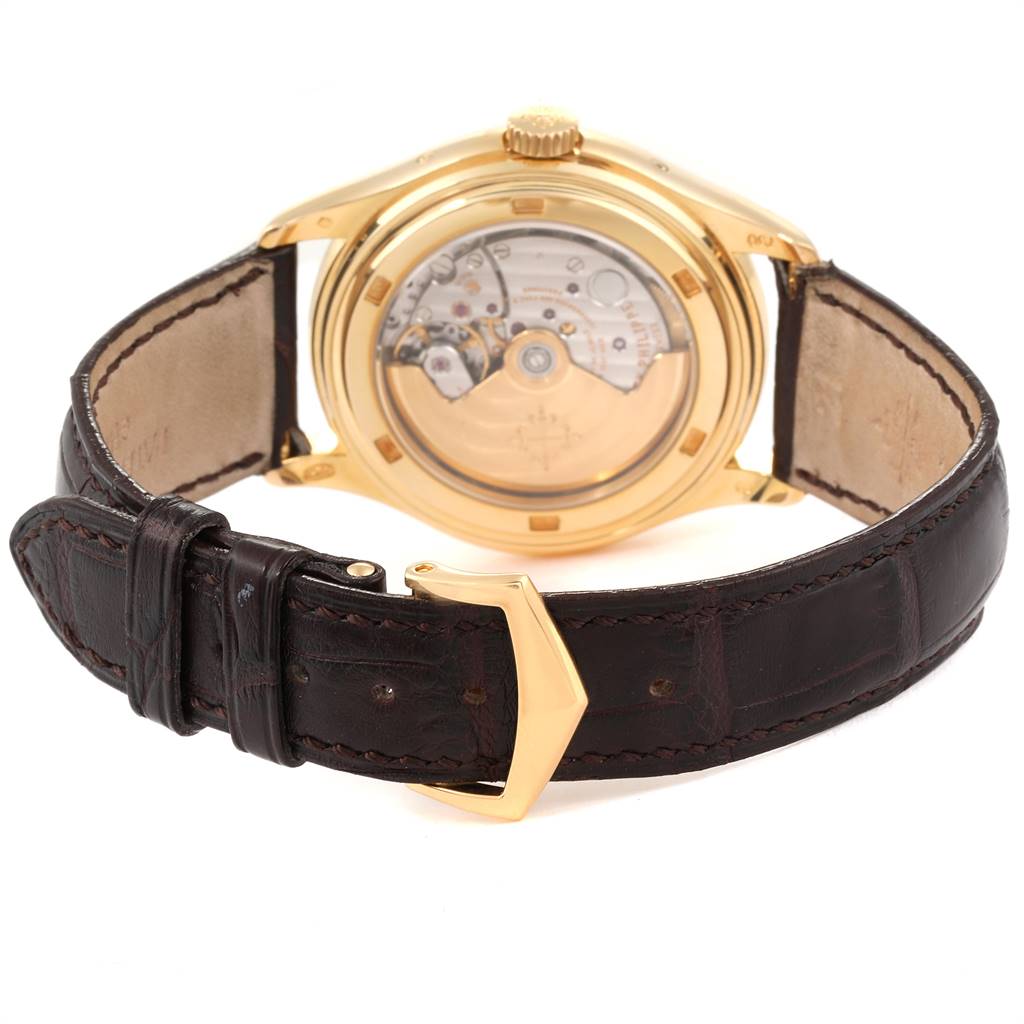 The image shows the back view of the Patek Philippe 5146J Men
s Yellow Gold Beige Dial 5146J Men
s Yellow Gold Beige Dial Complicated Annual Calendar Yellow Gold Mens Watch 5146J, highlighting its movement and leather strap.