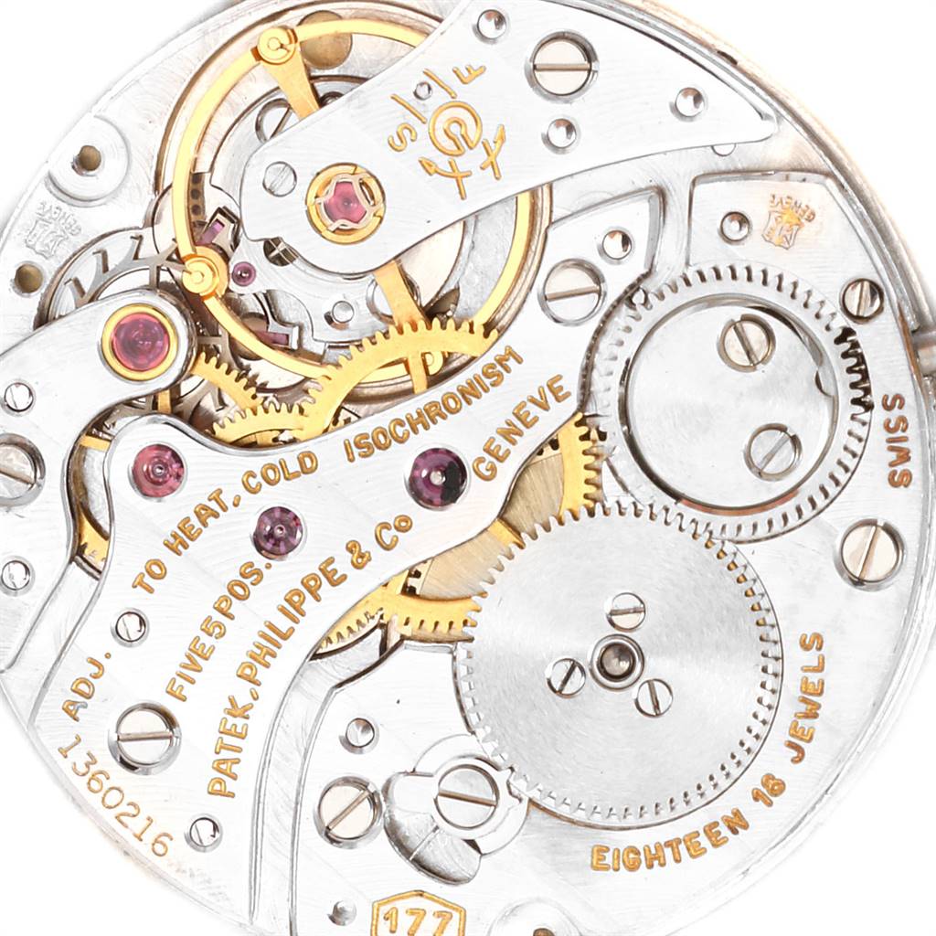This image shows the intricate internal mechanism of a Vintage Patek Philippe watch, showcasing gears and inscriptions.